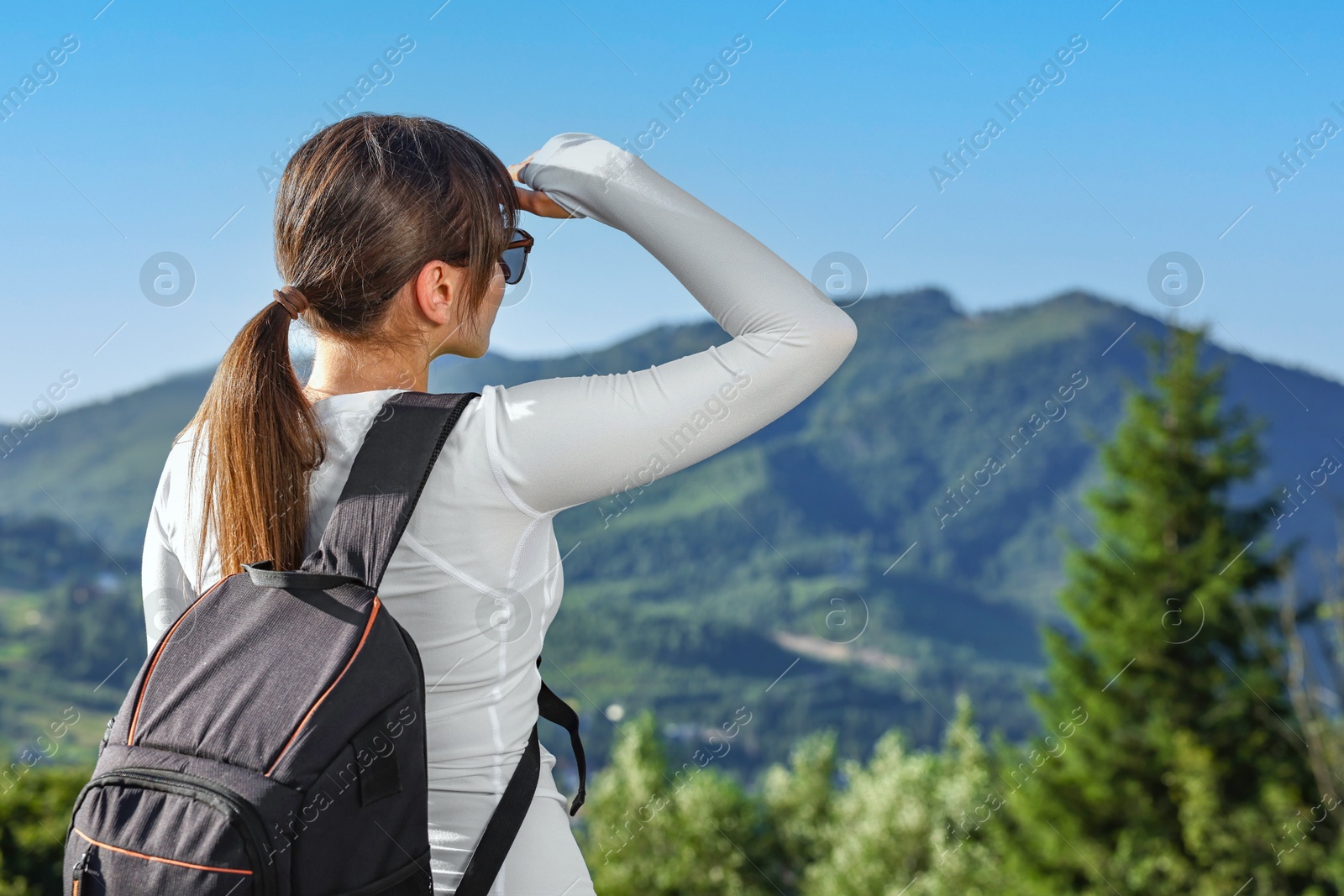 Photo of Young woman in sunglasses with backpack in beautiful mountains