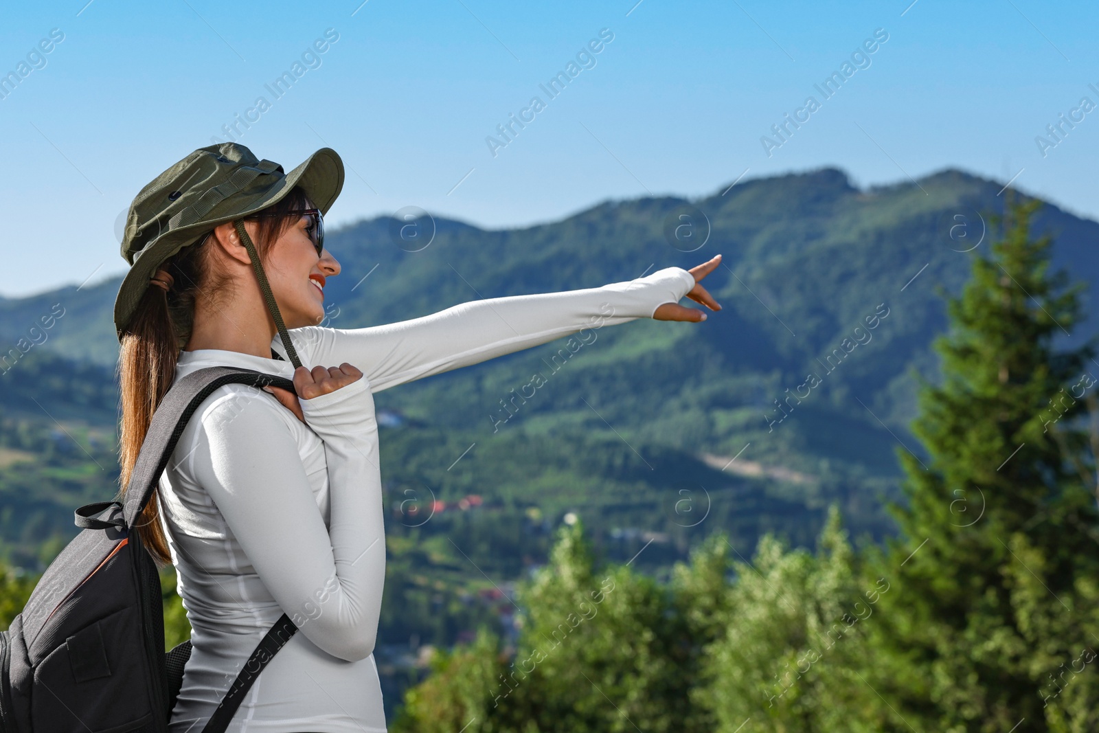 Photo of Young woman with backpack in beautiful mountains, space for text