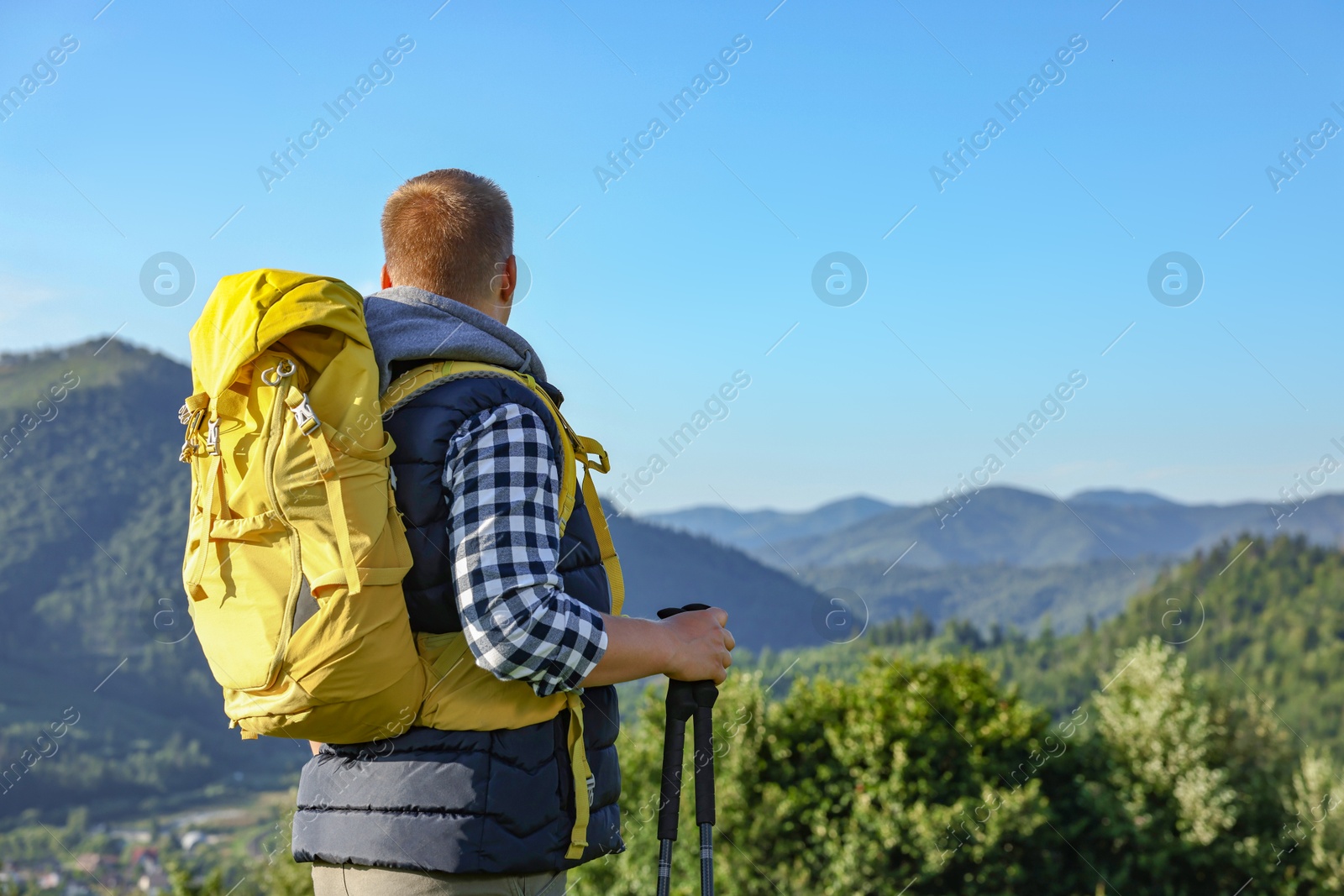 Photo of Man with backpack and binoculars in beautiful mountains, space for text