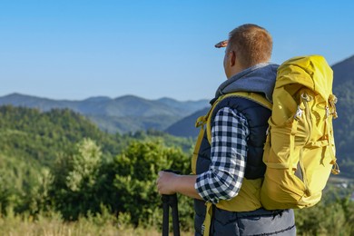 Photo of Man with backpack and binoculars in beautiful mountains, space for text