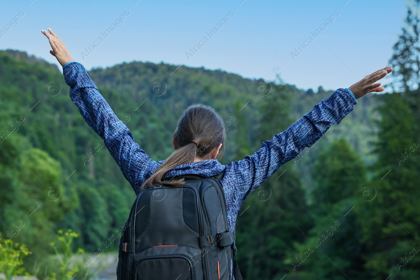 Photo of Woman with backpack in beautiful mountains, back view