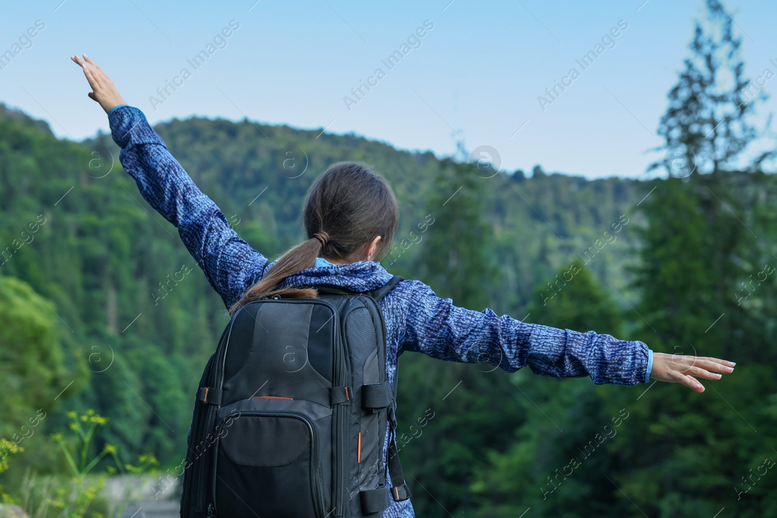 Photo of Woman with backpack in beautiful mountains, back view