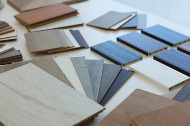 Photo of Different samples of wooden flooring on white table