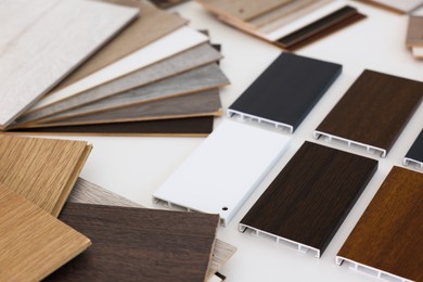 Photo of Different samples of wooden flooring on white table