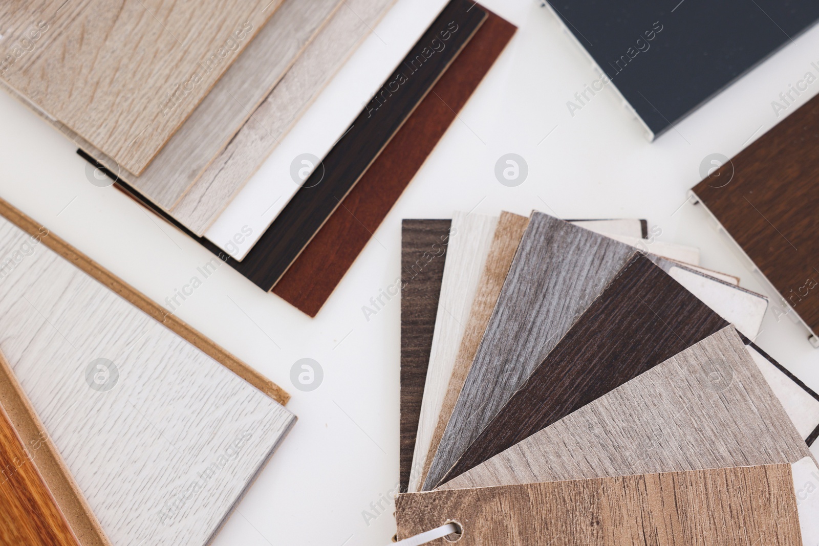 Photo of Different samples of wooden flooring on white table, top view