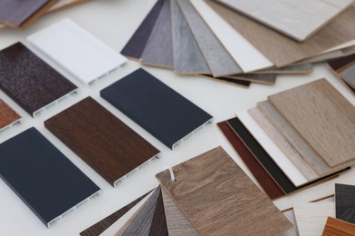 Photo of Different samples of wooden flooring on white table