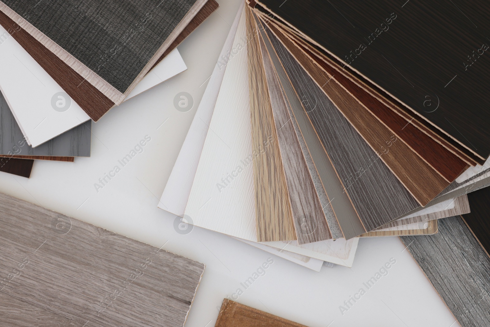 Photo of Different samples of wooden flooring on white table, top view