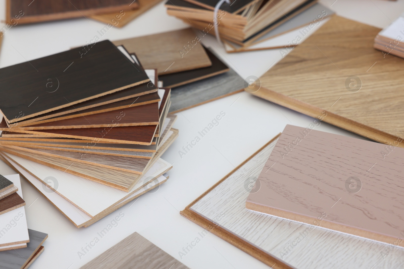 Photo of Different samples of wooden flooring on white table