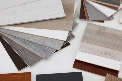 Photo of Different samples of wooden flooring on white table