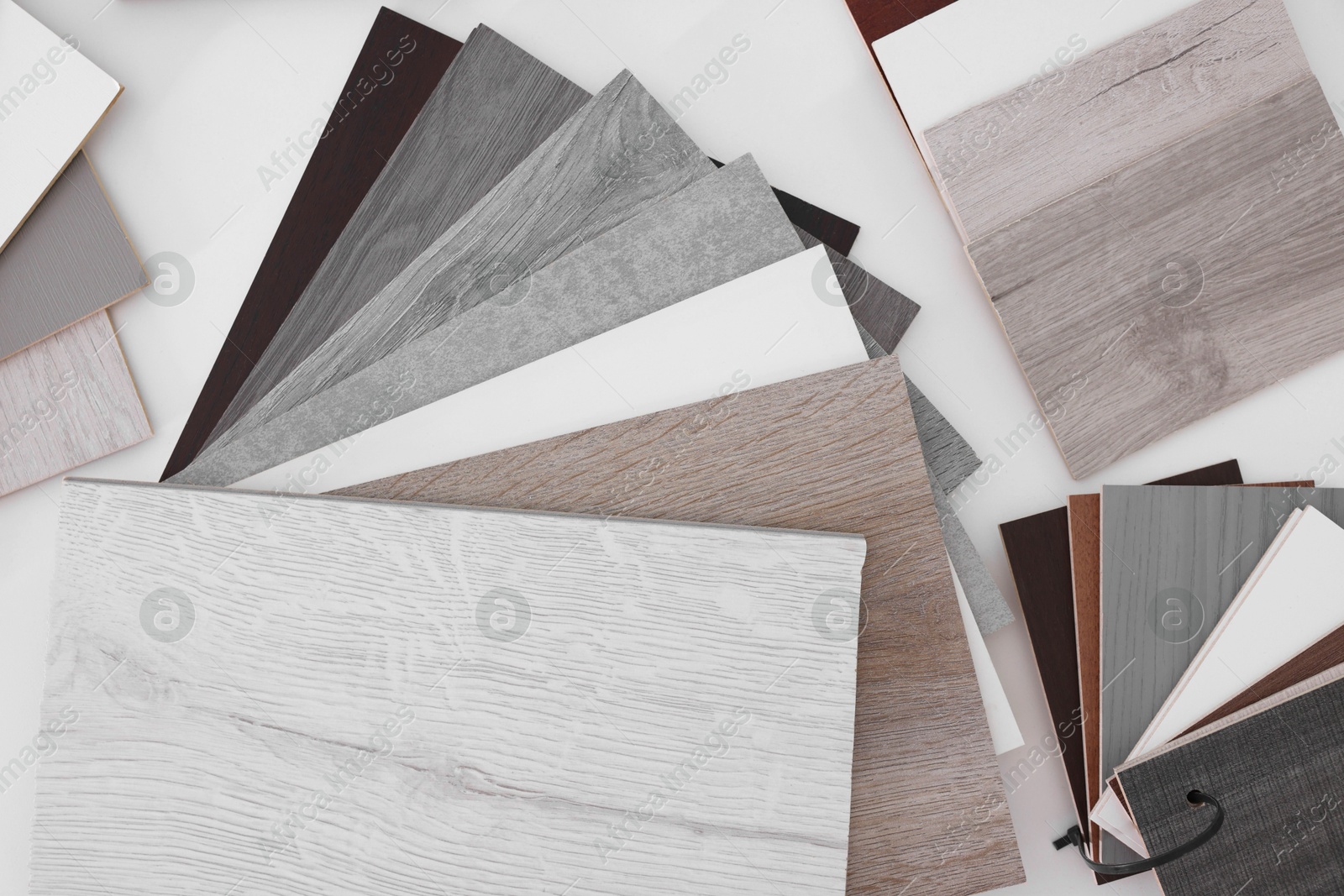 Photo of Different samples of wooden flooring on white table, top view