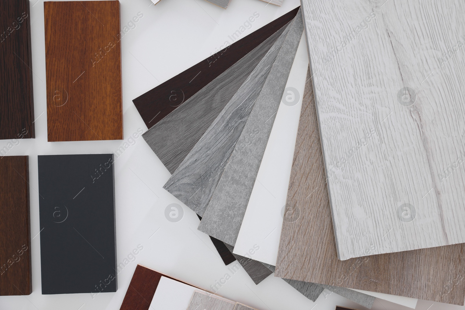 Photo of Different samples of wooden flooring on white table, top view