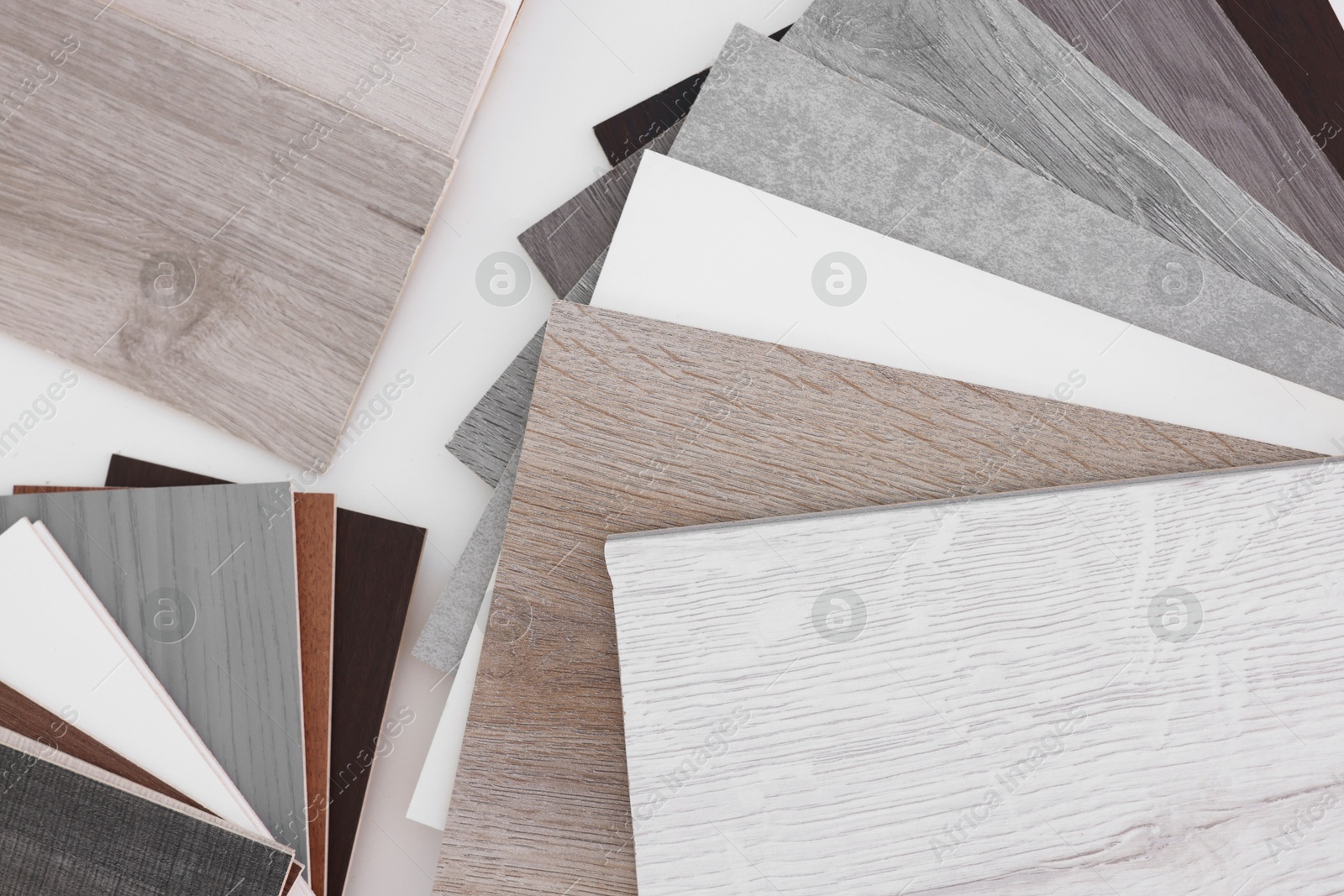 Photo of Different samples of wooden flooring on white table, top view