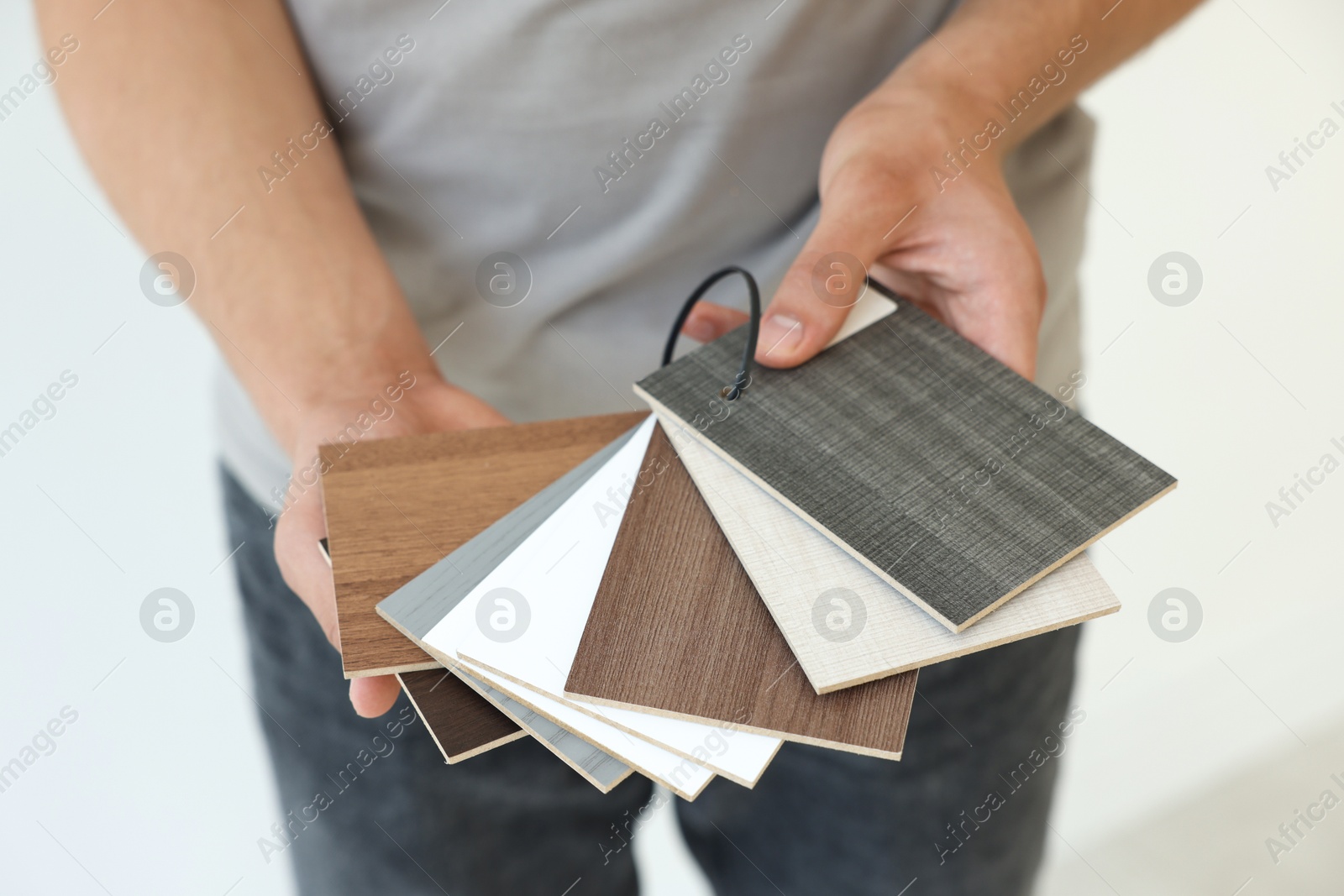 Photo of Man with samples of wooden flooring indoors, closeup