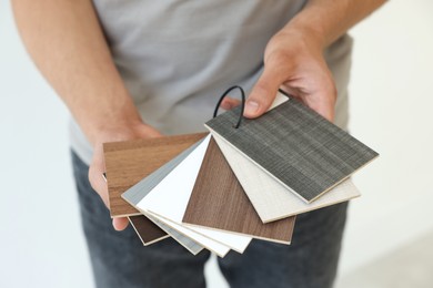 Photo of Man with samples of wooden flooring indoors, closeup