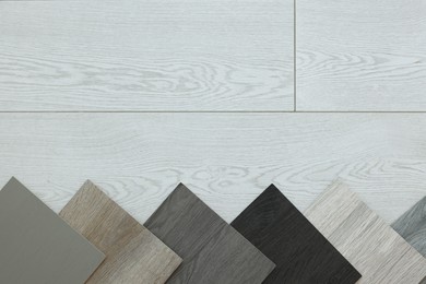 Photo of Different samples of wooden flooring indoors, top view. Space for text