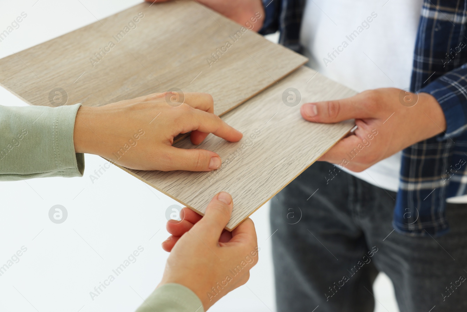 Photo of People choosing samples of wooden flooring indoors, closeup