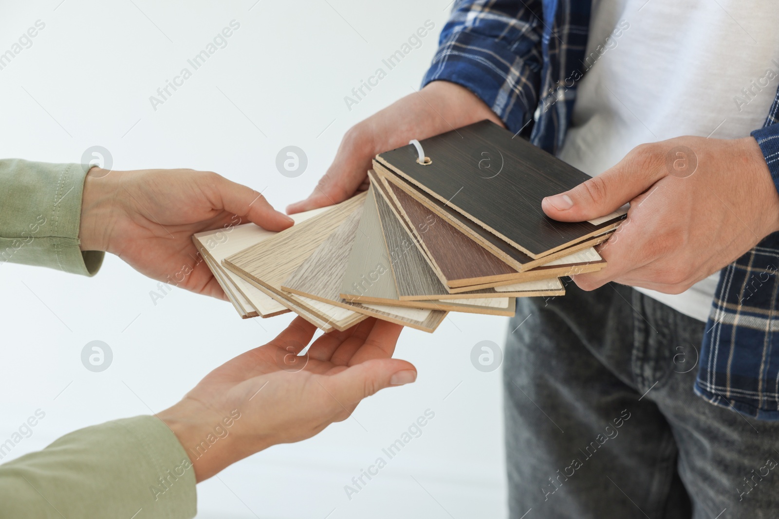 Photo of People choosing samples of wooden flooring indoors, closeup