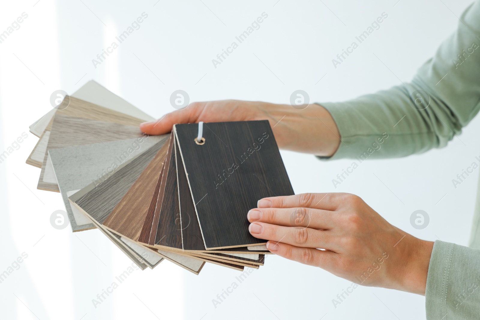 Photo of Woman with samples of wooden flooring indoors, closeup