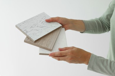 Photo of Woman with samples of wooden flooring indoors, closeup