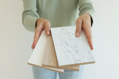 Photo of Woman with samples of wooden flooring indoors, closeup