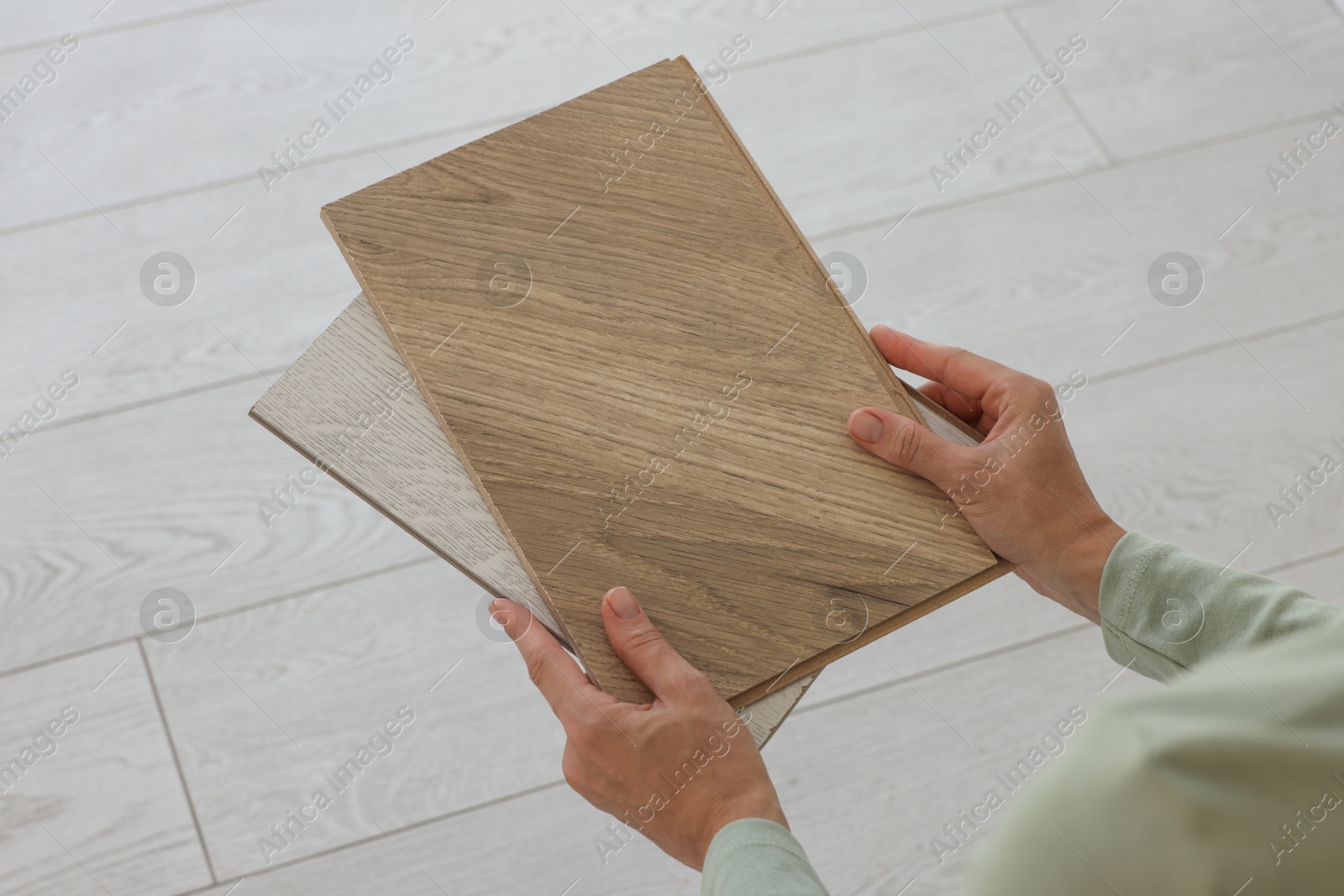 Photo of Woman with samples of wooden flooring indoors, closeup