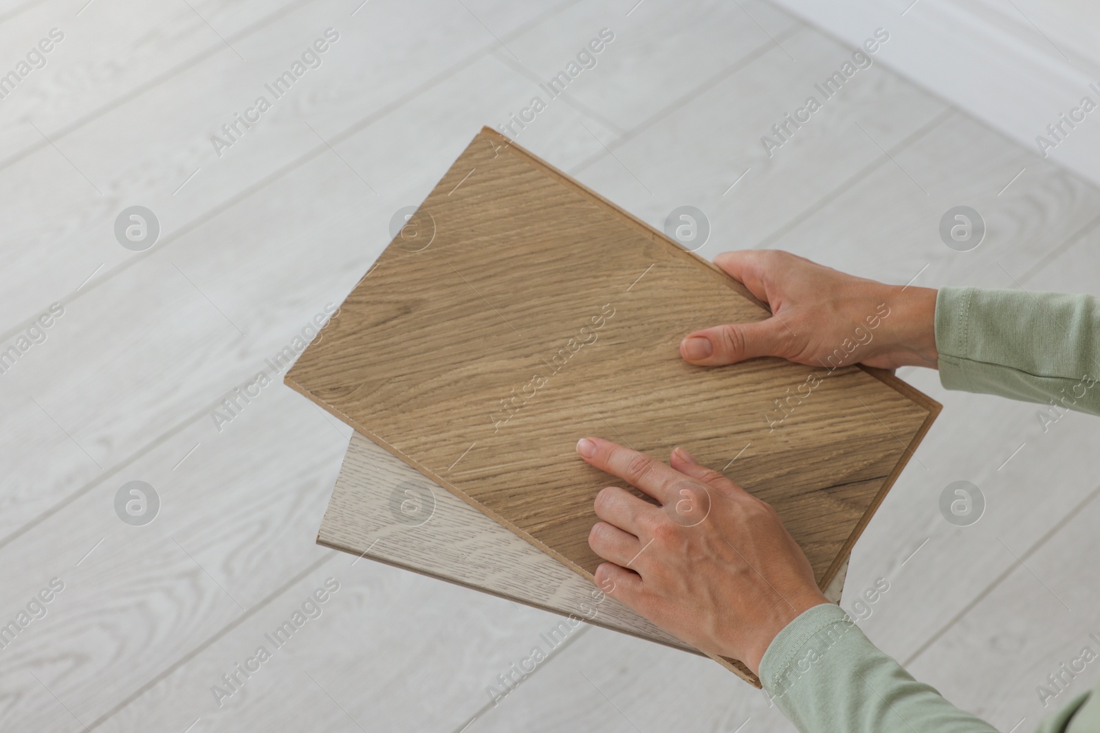 Photo of Woman with samples of wooden flooring indoors, closeup