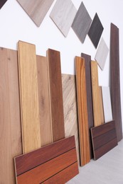 Photo of Many different samples of wooden flooring on light background