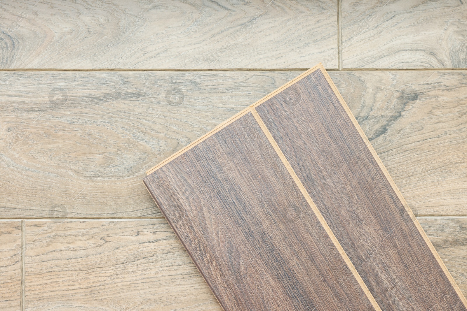 Photo of Laminate flooring pieces on wooden surface, top view