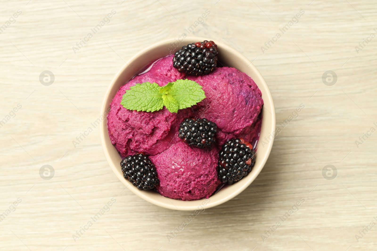 Photo of Delicious blackberry sorbet, fresh berries and mint in bowl on wooden table, top view