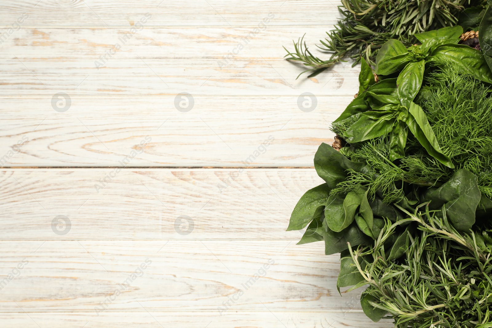 Photo of Different fresh herbs on white wooden table, top view. Space for text