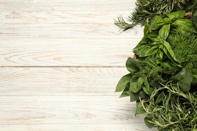 Photo of Different fresh herbs on white wooden table, top view. Space for text