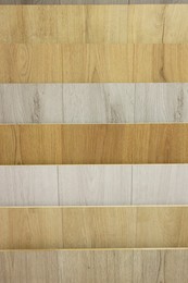 Photo of Many different samples of wooden flooring as background, closeup