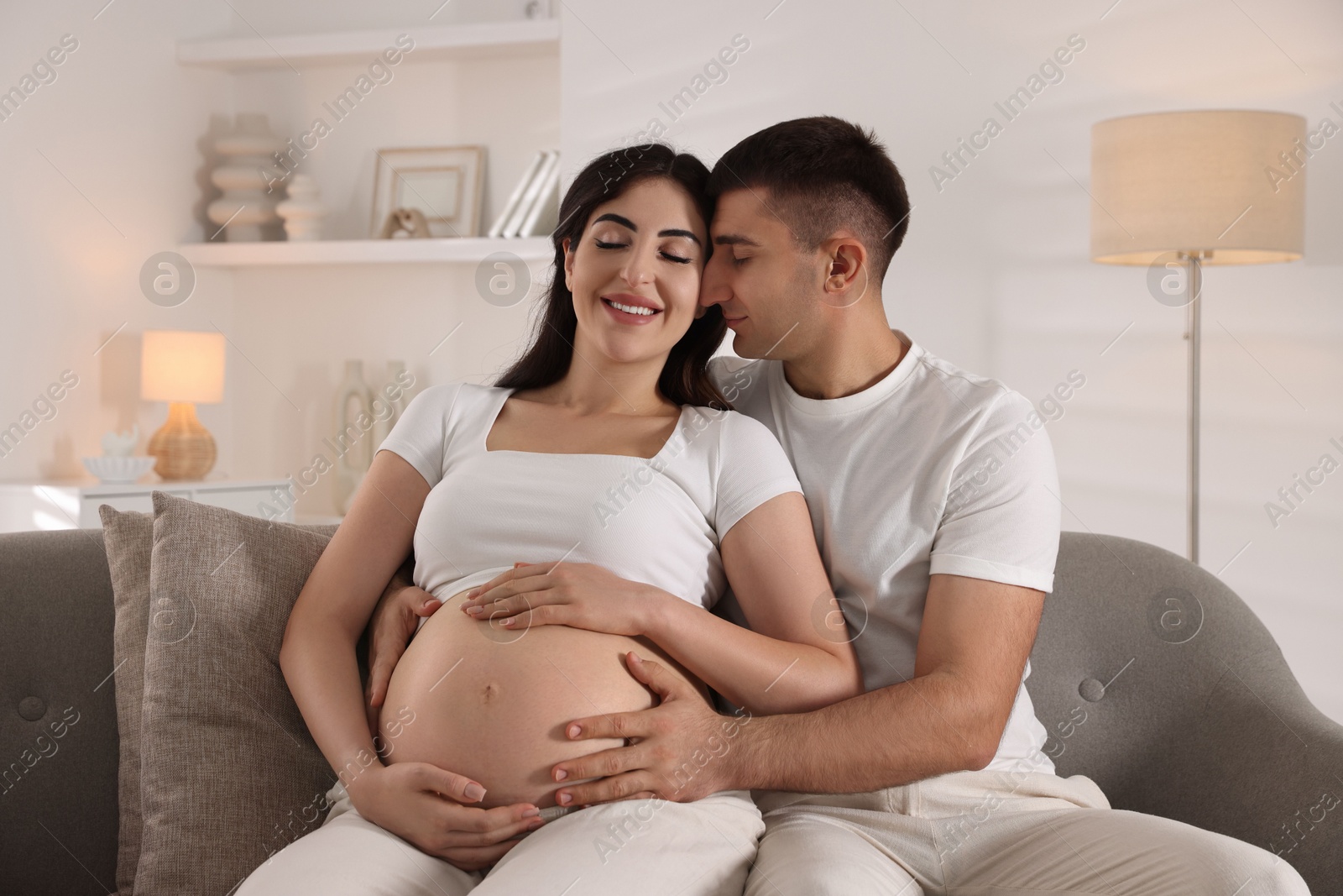 Photo of Beautiful pregnant woman spending time with her husband at home