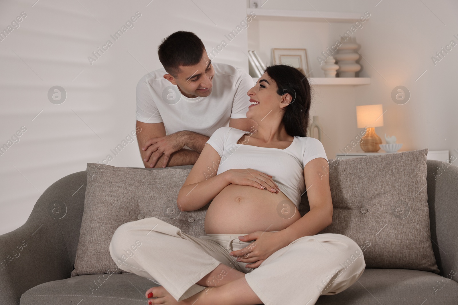 Photo of Beautiful pregnant woman spending time with her husband at home