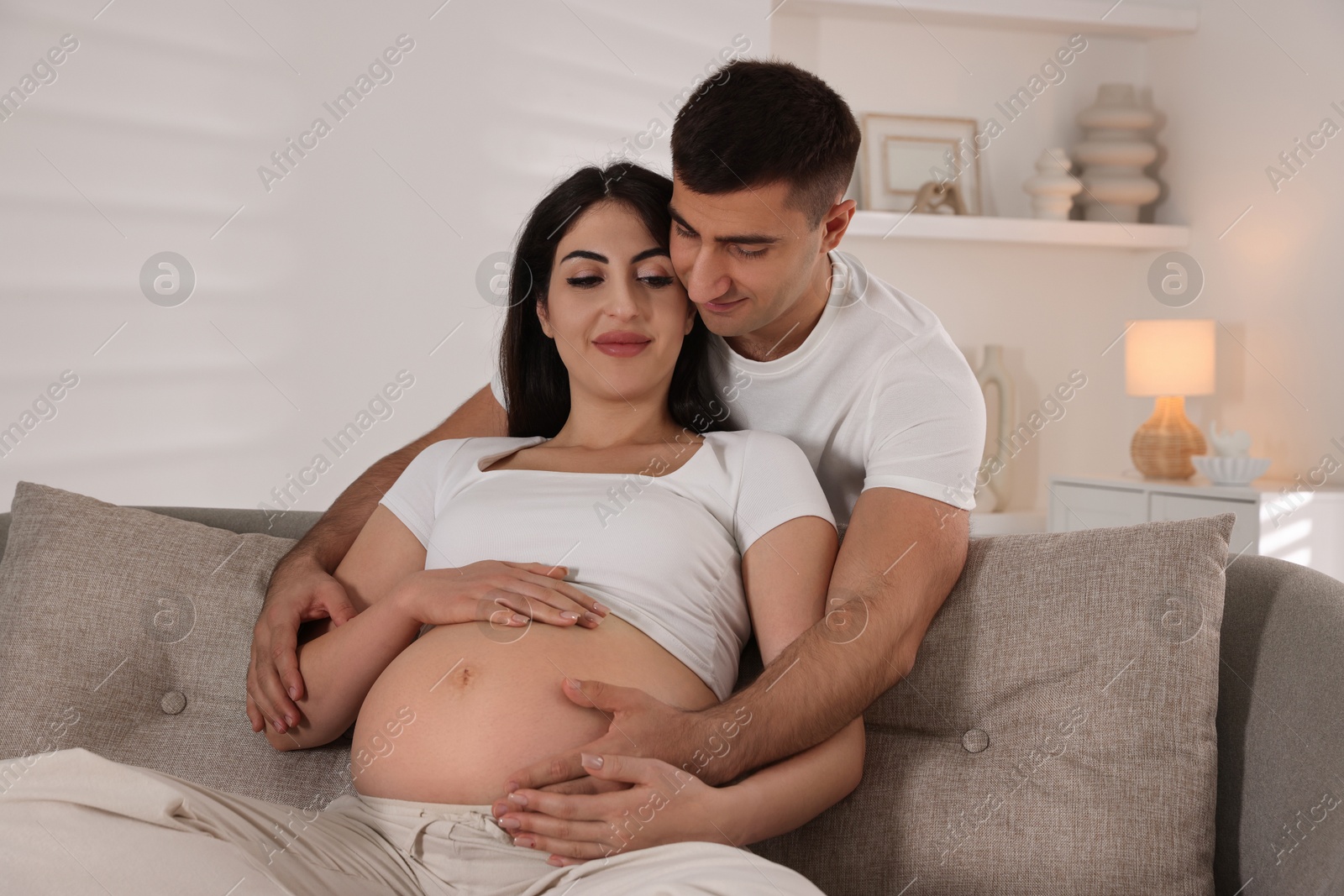 Photo of Beautiful pregnant woman spending time with her husband at home