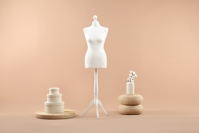 Female mannequin and vase on beige background