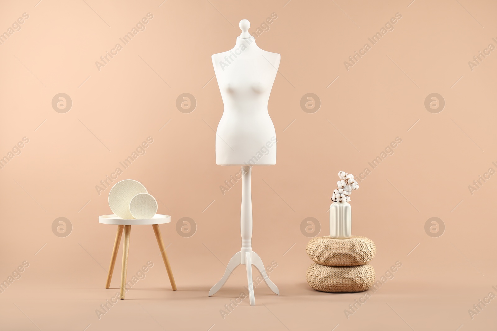 Photo of Female mannequin and vase on beige background