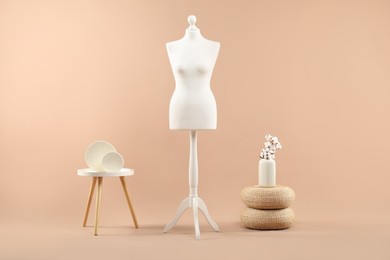 Female mannequin and vase on beige background