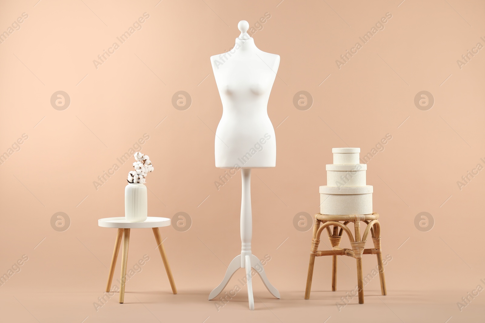 Photo of Female mannequin and vase on beige background