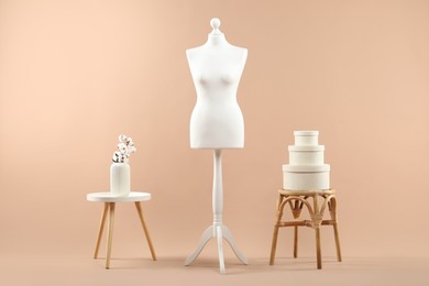 Female mannequin and vase on beige background