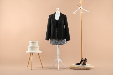 Photo of Mannequin with stylish dress, jacket and shoes on beige background