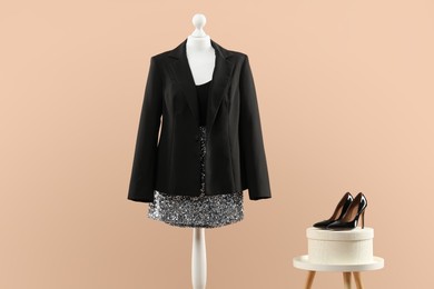 Photo of Mannequin with stylish dress, jacket and shoes on beige background