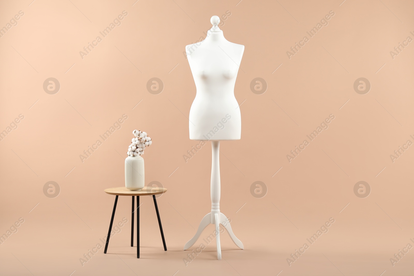 Photo of Mannequin and stylish vase on beige background