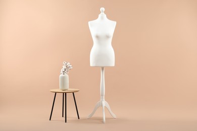 Photo of Mannequin and stylish vase on beige background