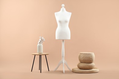 Photo of Mannequin and stylish vase on beige background