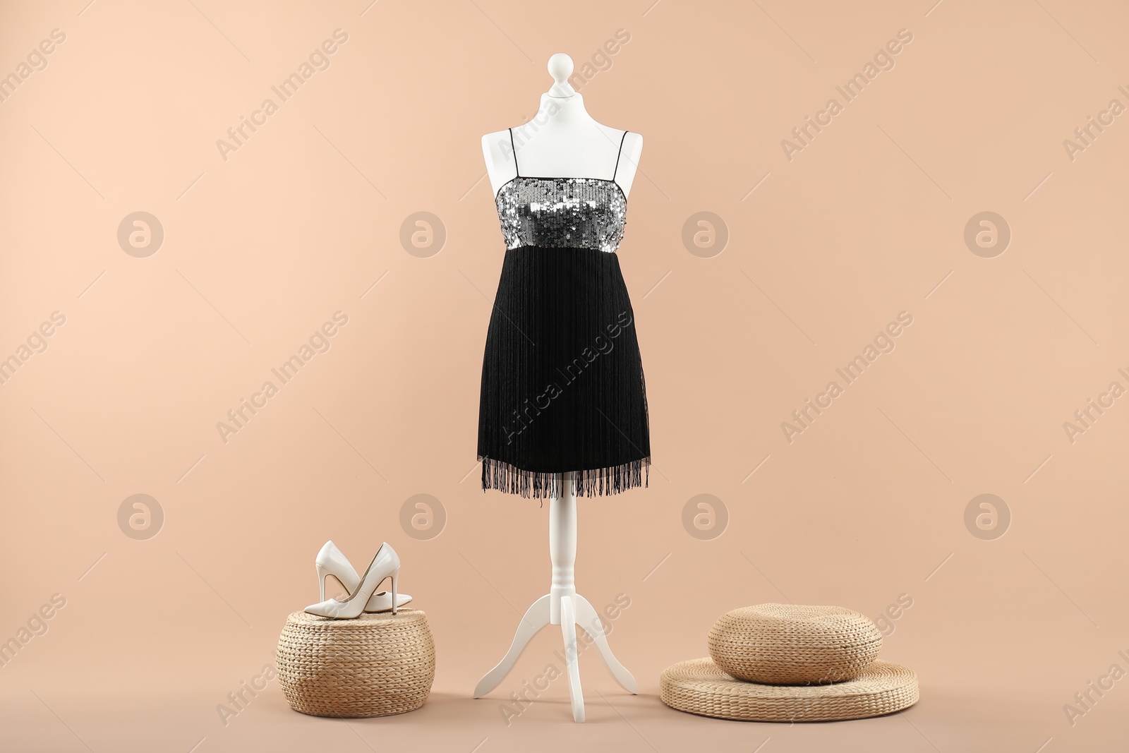 Photo of Mannequin with stylish dress and shoes on beige background