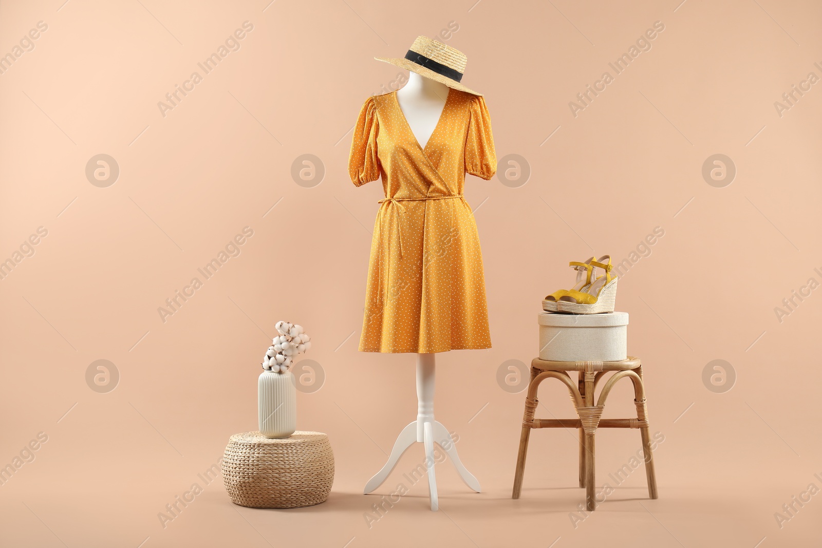 Photo of Mannequin with stylish dress, shoes and hat on beige background