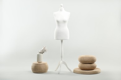 Mannequin and vase on light grey background