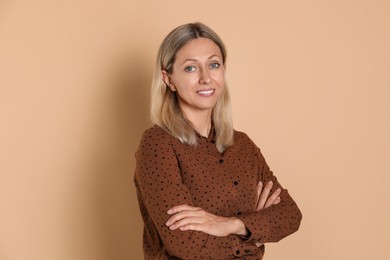 Portrait of beautiful smiling woman on beige background