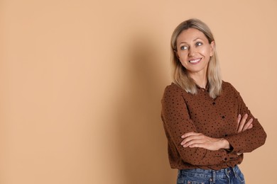 Photo of Portrait of beautiful smiling woman on beige background, space for text